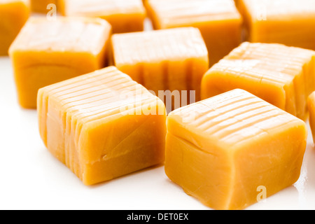 Vanilla caramel candy unwrapped on a white background. Stock Photo