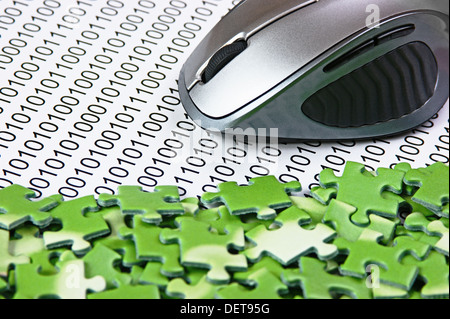 computer mouse and puzzles on a binary code Stock Photo