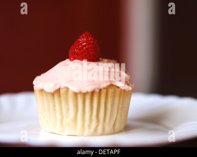 Single, Isolated homemade strawberry cupcake on a white plate. Stock Photo