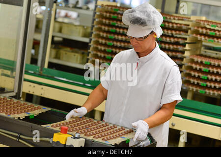 An employee of Stollwerk (GmbH) presents a palette of Christmas chocolate balls in Saalfeld, Germany, 18 September 2013. Thuringian chocolate manufacturers are in the middle of preprarations for the Christmas season. For some, it is the the most profitable time of the year. Photo: Marc Tirl Stock Photo