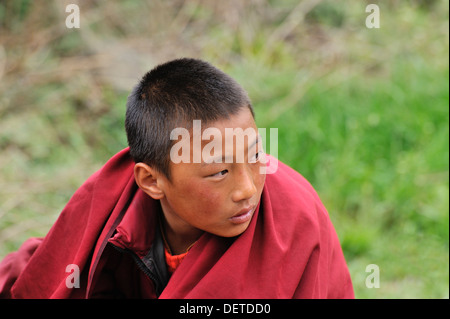 Young monks watching dancers at Domkhar Tsechu festival held in a monastery in the village of Domkhar, Bumthang, Bhutan Stock Photo