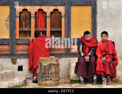 Young monks watching dancers at Domkhar Tsechu festival held in a monastery in the village of Domkhar, Bumthang, Bhutan Stock Photo