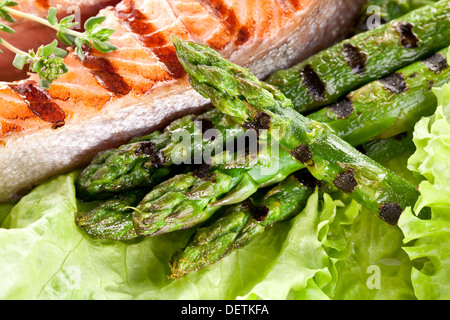 Grilled salmon and asparagus over lettuce leaves. Close up shot. Stock Photo