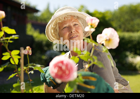 Relaxed mature lady working in her garden - Outdoors Stock Photo