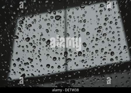 Abstract photograph of a window pane with raindrops on symbolising dull wintry weather Stock Photo