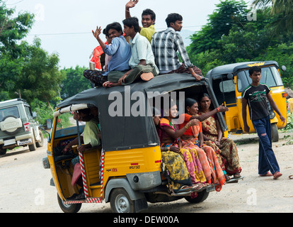 Indian auto rickshaw full of people, with passengers sitting on the roof. Andhra Pradesh, India Stock Photo