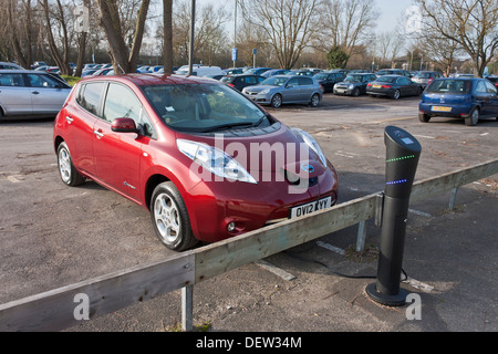 A Nissan Leaf car being charged at an electric charging station. Stock Photo