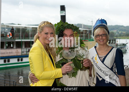 Herbert Graedtke dressed as wine god 'Bacchus', Saxonian wine queen Katja Riedel (L) and Miss Albrechtsburg, Nadin Busch, pose during a photo shooting for the Radebeul wine festival 2013 (Radebeuler Weinfestes 2013) on a steamer of the Saxonian steam navigation in Radebeul, Germany, 24 September 2013. The 23rd wine festival will take place from 27 to 29 September in Radebeul and Meissen. Photo: ARNO BURGI Stock Photo