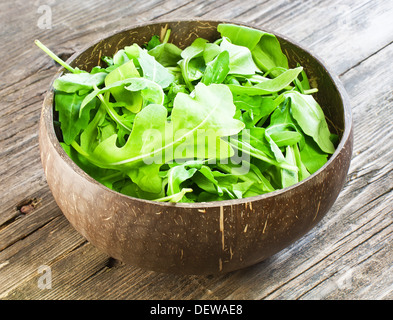 resh arugula salad on wooden table Stock Photo