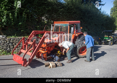 farmer farm labourer laborer repairing tractor Stock Photo