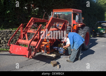 farmer farm labourer laborer repairing tractor Stock Photo