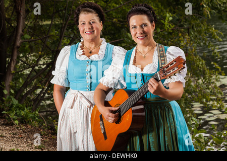 Two Bavarian women in dirndls singing Stock Photo