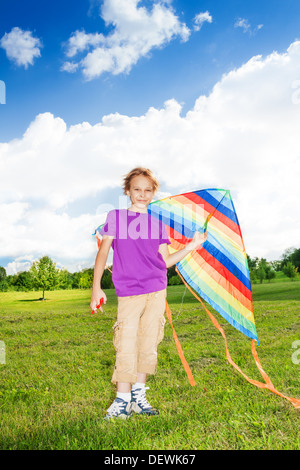 Boys and girls with kids stand in the field with colorful kite Stock Photo