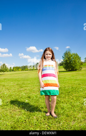 Beautiful portrait of happy smiling little girl with long hairs walking outside on sunny day Stock Photo