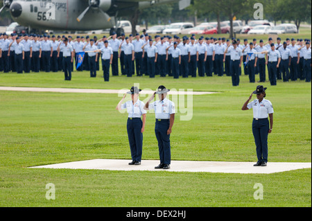 US Air Force Airmen salute to the American flag during the singing of ...