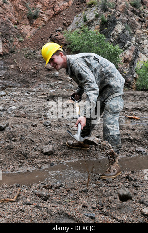 CHEYENNE MOUNTAIN AFS, Colo. -- Spc. Jordan Bellows, mechanic, 615th Engineer Company, 52nd Engineer Battalion, digs a drainage