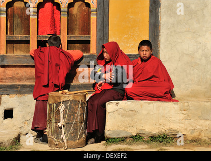 Young monks watching dancers at Domkhar Tsechu festival held in a monastery in the village of Domkhar, Bumthang, Bhutan Stock Photo