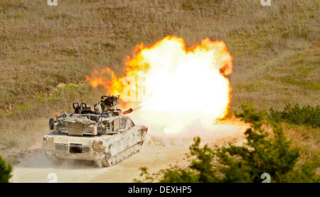 A U.S. Army M1A2 Abrams tank crew assigned to the 1st Battalion, 12th Cavalry Regiment, 3rd Brigade Combat Team, 1st Cavalry Division, fires a 120 mm round from its main gun at a target for crew qualification during a Gunnery Table VI live-fire exercise a Stock Photo