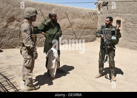 An Afghan National Army (ANA) Soldier with 215 ANA Corps, speaks with a local resident in Barrmo, Washir district, Afghanistan, Stock Photo