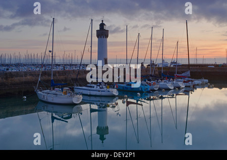 Lighthouse and boats reflected in the eastern harbor in the early morning, Port-Haliguen in Quiberon, southern Brittany Stock Photo