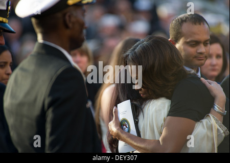 U.S. First Lady Michelle Obama hugs friends and family of those killed during a Navy Yard shooting at a memorial for those killed during a shooting at the Navy Yard, at the Marine Barracks in Washington D.C., Sept. 22, 2013. 12 people were killed Sept. 18 Stock Photo