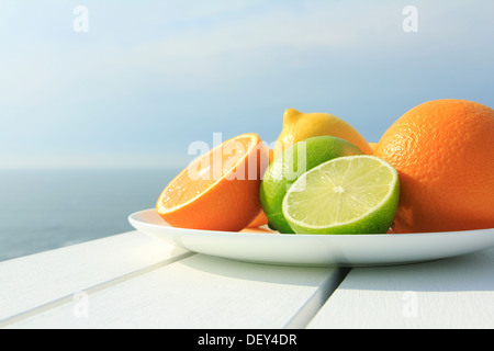 Oranges, lemons and limes by the coast Stock Photo
