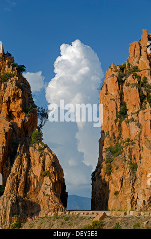 The typical bizarre red rocks of the Calanche of Piana below a blue sky and some clouds. The Calanche of Piana is in the western