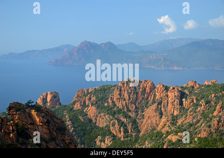 The typical bizarre red rocks of the Calanche of Piana and the mediterranean sea at the Gulf of Porto in the background. The Stock Photo