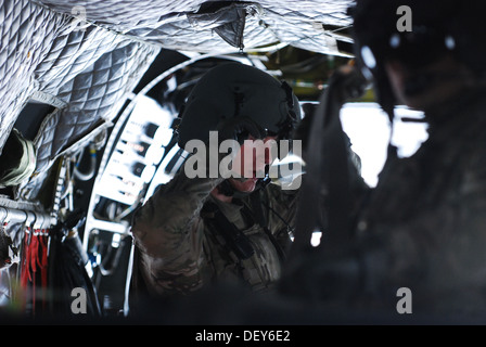 Pfc. Zach Fike, a CH-47 Chinook helicopter crew chief assigned to B Company, 2nd Battalion (General Support), 149th Aviation Regiment (Texas/Oklahoma National Guard), serving under the 10th Combat Aviation Brigade, lowers his helmet visor after securing c Stock Photo