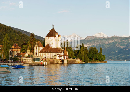 Schloss Oberhofen Castle on Lake Thun, Bernese Oberland with the mountains Moench, Eiger and Jungfrau at back, Bernese Oberland Stock Photo