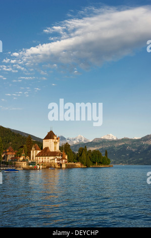 Schloss Oberhofen Castle on Lake Thun, Bernese Oberland with the mountains Moench, Eiger and Jungfrau at back, Bernese Oberland Stock Photo