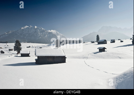 Snow-covered pastures and hay barns, Wetterstein range at back, Mittenwald, Upper Bavaria, Bavaria, Germany Stock Photo