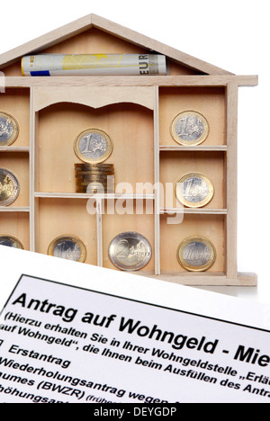 Miniature house with euro coins and application form for home assistance Stock Photo