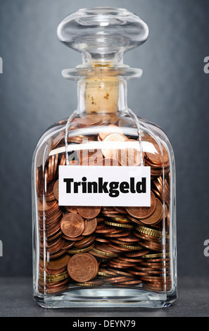 Glass jar filled with euro cent coins, labelled Trinkgeld, German for tip Stock Photo