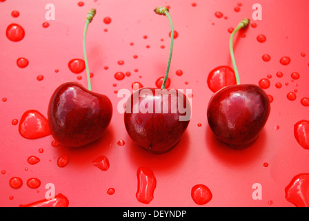 Three red ripe cherries with drops of water Stock Photo