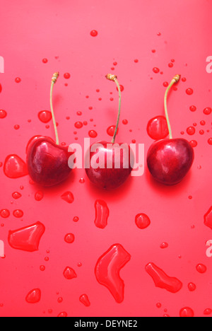 Three red ripe cherries with drops of water Stock Photo