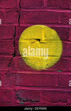 Yellow dot on a graffiti wall Stock Photo