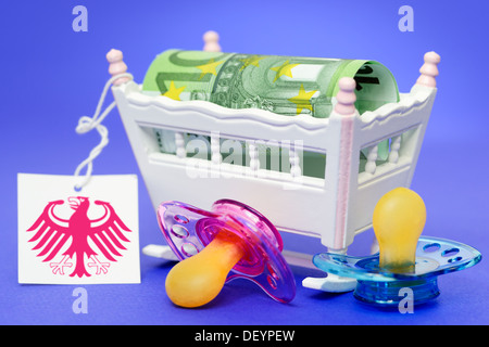 Child cradle with euro hundred and label with federal eagle, symbolic photo care money, Kinderwiege mit Hundert-Euro-Schei Stock Photo