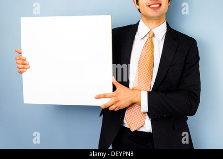 Businessman is holding a blank white sign Stock Photo