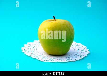 Green Delicious apple on a paper doily Stock Photo