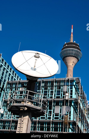 TV satellite transmission system in front of the building of the WDR local tv studio, behind the Rheinturm radio and tv tower Stock Photo
