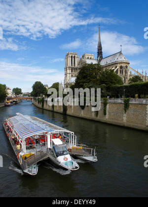 Excursion boat on the Seine river and cathedral Notre Dame in Paris, France, Europe Stock Photo
