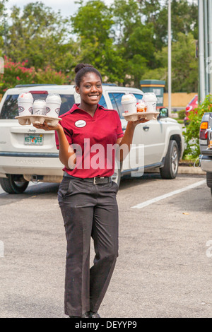 Server delivering milk shakes to waiting cars at the Chick-fil-a