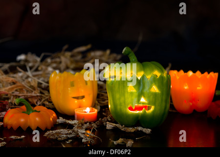 scary faces carved on bell peppers on a dark background for halloween Stock Photo