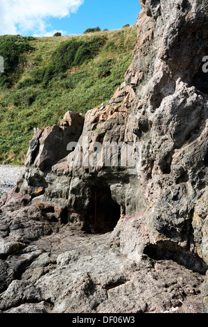hole cut out of rock on the gobbins cliff shoreline path islandmagee larne northern ireland Stock Photo