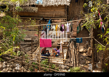 Young people sitting outside a hut, laundry hanging on washing lines, Mae La refugee camp for the Karen tribe near Mae Sot on Stock Photo