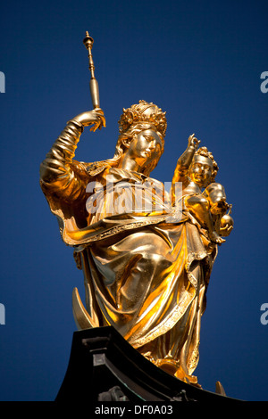 golden Virgin Mary atop the Mariensäule on the central square Marienplatz in Munich, Bavaria, Germany Stock Photo