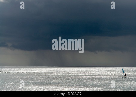 One surfer out at sea with a storm approaching, near Pointe aux Piments, Mauritius, Africa, Indian Ocean Stock Photo