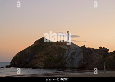 Sunrise behind the lighthouse at Castle Point and a tide pool at the Wairarapa Coast, New Zealand