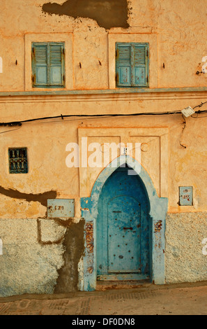 A facade with a typically shaped blue door and blue windows on a white wall in Sidi Ifni, Morocco, Africa Stock Photo